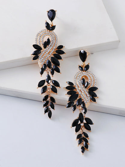 Ornate black and gold earrings on a white surface